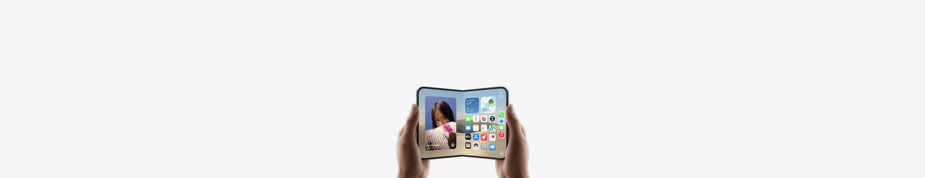 iPhone Duo, im Querformat in zwei Händen gehalten, aufgeklappt, das Display zeigt den Homescreen