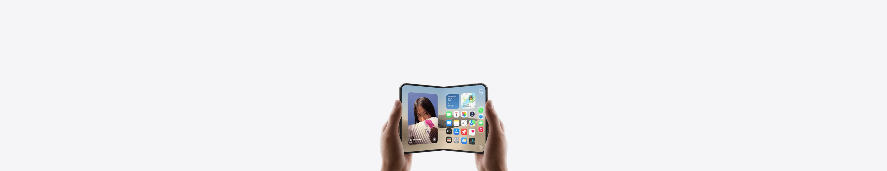iPhone Duo, held by two hands in landscape orientation, unfolded, interior display features Home Screen