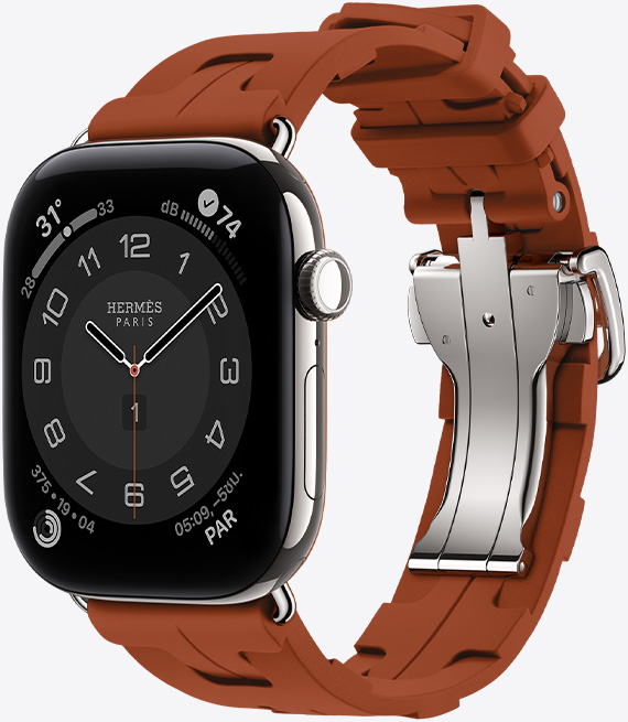 Apple Watch Hermès Series 12, หน้าปัดนาฬิกาอนาล็อก Circulaire, (เข็มชั่วโมง เข็มนาที และเข็มวินาที, กลไกหน้าปัด: สภาพอากาศ, เสียงรบกวน, วงแหวนกิจกรรม และเวลาปารีส), ตัวเรือนไทเทเนียม, สีเงิน, ภายนอกด้านขวา, Digital Crown, ปุ่มด้านข้าง, จับคู่กับสายแบบ Simple Tour Kilim, สี Cuivre (น้ำตาล), วัสดุยางอัดขึ้นรูป, ดีไซน์เรขาคณิตแบบประกบล็อคเข้าด้วยกัน, ตัวล็อคโลหะสีเงิน