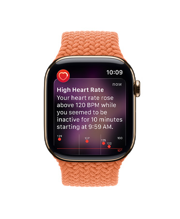 Apple Watch Series 11, титановий корпус золотистого кольору, на екрані показано сповіщення про високий серцевий ритм, плетений монобраслет кольору «куркума»
