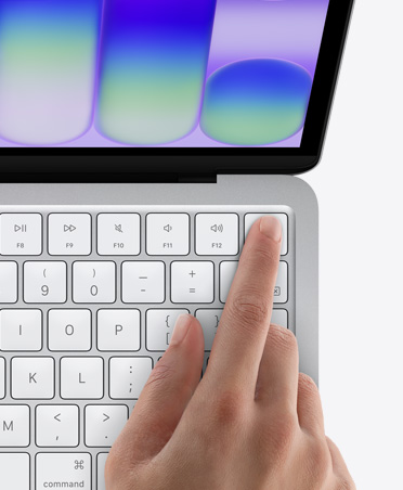 MacBook Neo, couleur argent, doigt d’une personne sur le capteur Touch ID situé dans le coin supérieur droit du clavier