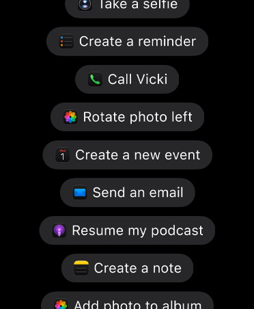 หน้าจอที่มีคำขอให้ Siri AI ทำสิ่งต่างๆ ในแอป เช่น ถ่ายเซลฟี่, สร้างรายการเตือนความจำ, โทรหาวิกกี้, หมุนรูปภาพไปทางซ้าย, สร้างกิจกรรมใหม่, ส่งอีเมล, กลับมาเล่นพ็อดคาสท์ของฉัน, สร้างโน้ต, เพิ่มรูปภาพลงในอัลบั้ม